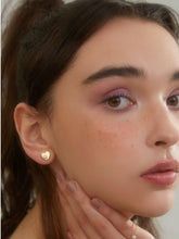 wearing Stella Heart Studs Earrings and single pearl ring